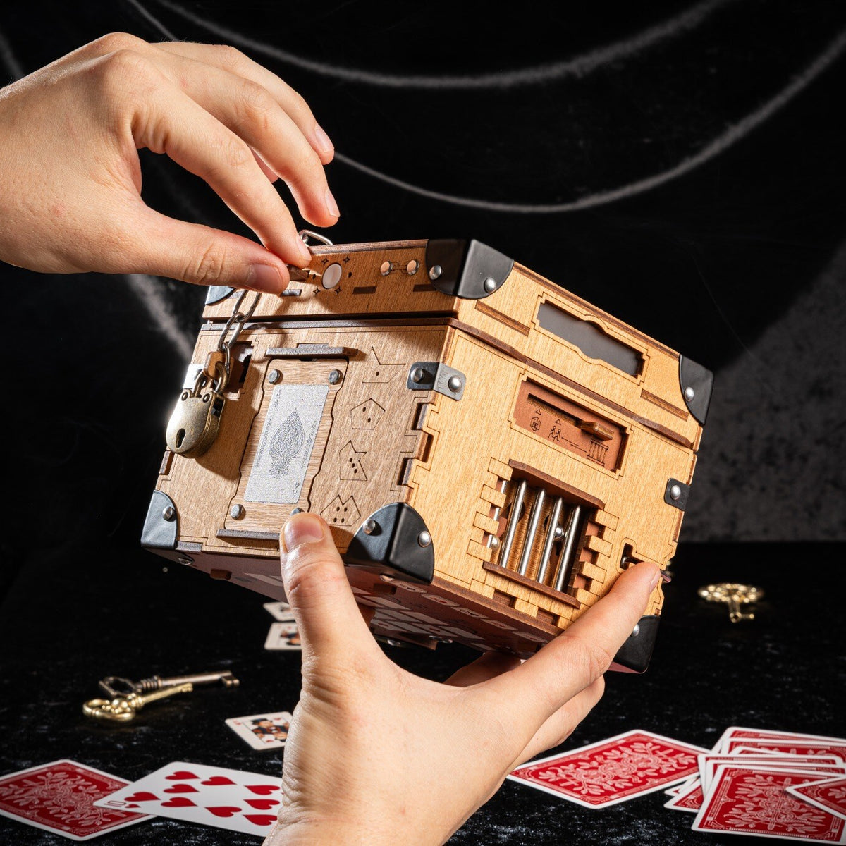 Houdini Double Escape Bundle træ-escape box holdt i hænder, toplåg med hængelås og udsmykkede metalhjørner synligt